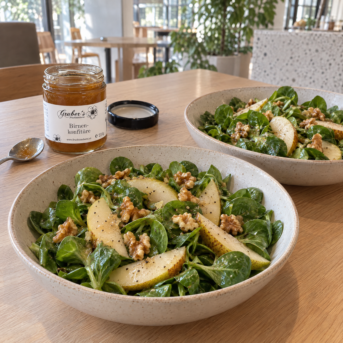 Zwei Schalen Feldsalat mit Birnenspalten, Walnüssen und Birnen-Senf-Dressing, daneben das geöffnete Gruber-Glas, sein schwarzer Deckel und ein kleiner Löffel auf einem hellen Holztisch (AI Generated)