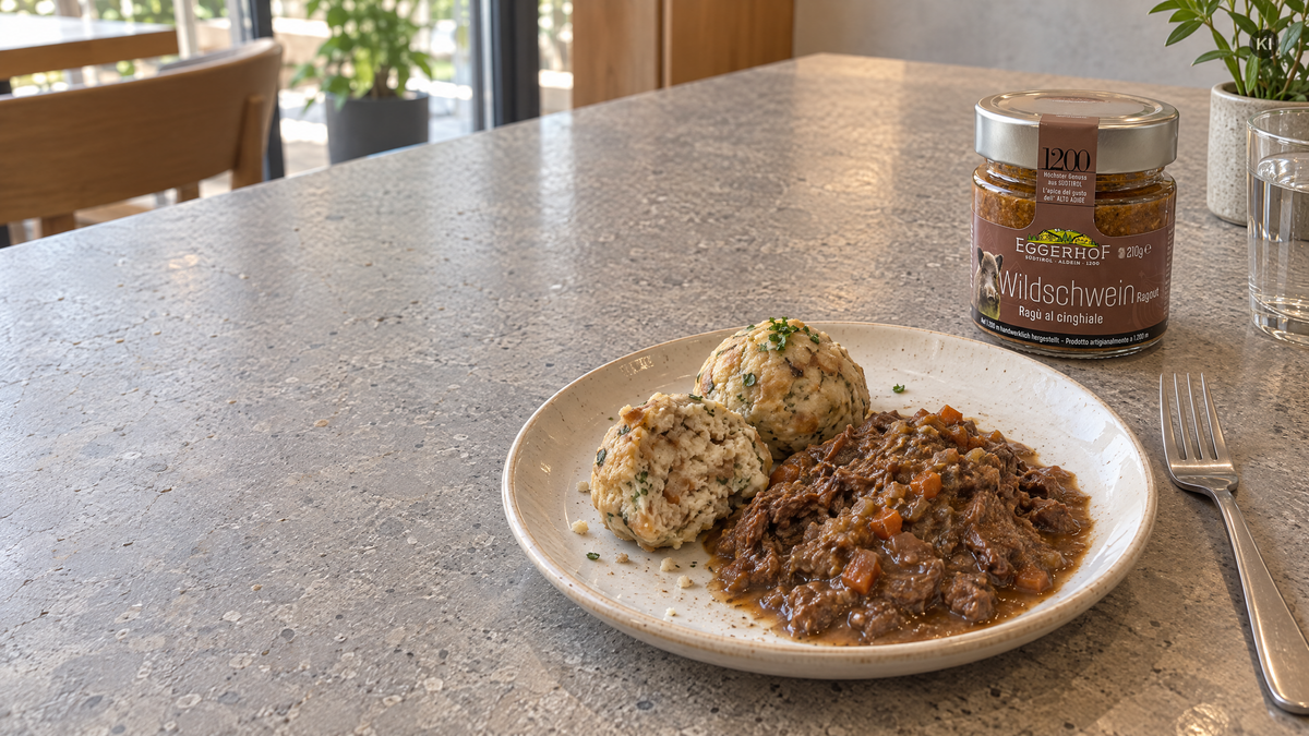 Semmelknödel mit Wildschwein-Ragout und originalem Eggerhof-Glas auf einem steinernen Cafétisch (AI Generated)